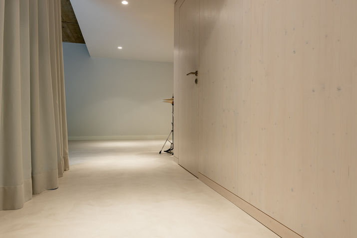 Couloir moderne avec mur en bois clair et rideau.