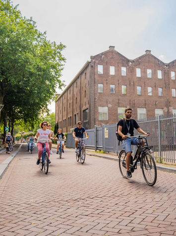 Traveler cycling through a historic square during an Amsterdam bike tour