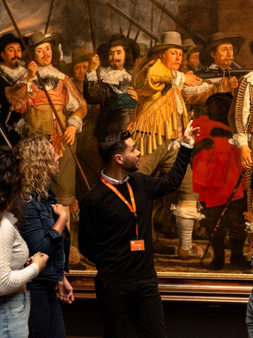 Travelers viewing a Dutch masterpiece on an Amsterdam museum tour