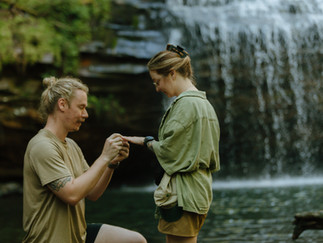 man proposing in front of beautiful waterfall