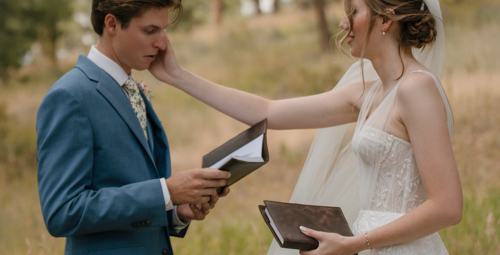 embracing couple reading vows to each other, woman in wedding dress