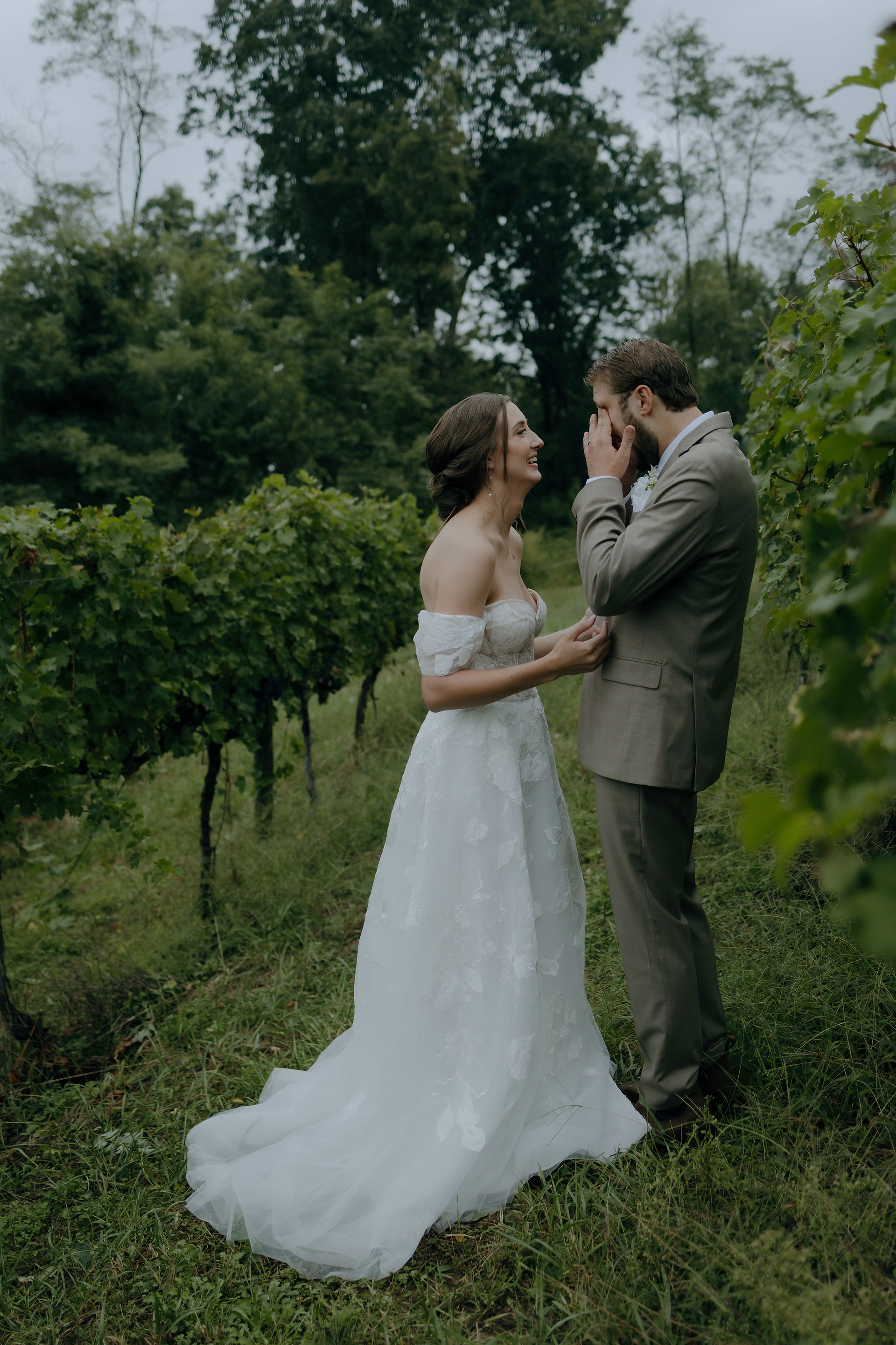 a bride and groom stands in a vineyard. the bride is reading off her vows.