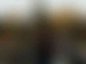 Couple kissing on bridge in front of autumn trees and mountain range