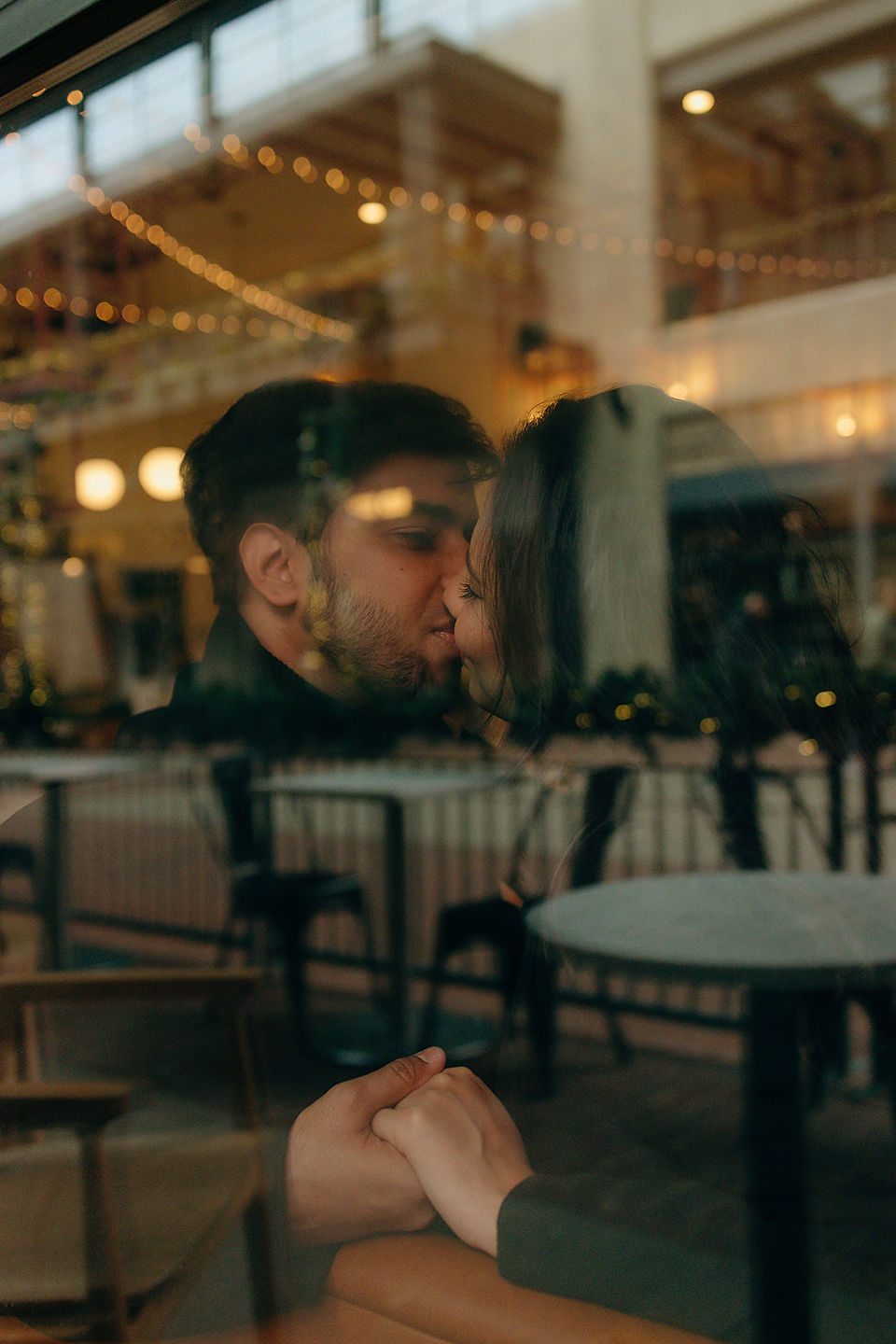 couple kissing on other side of window, lots of warm cozy lighting