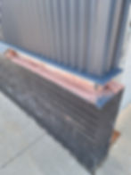 Corrugated metal siding with stone repair
