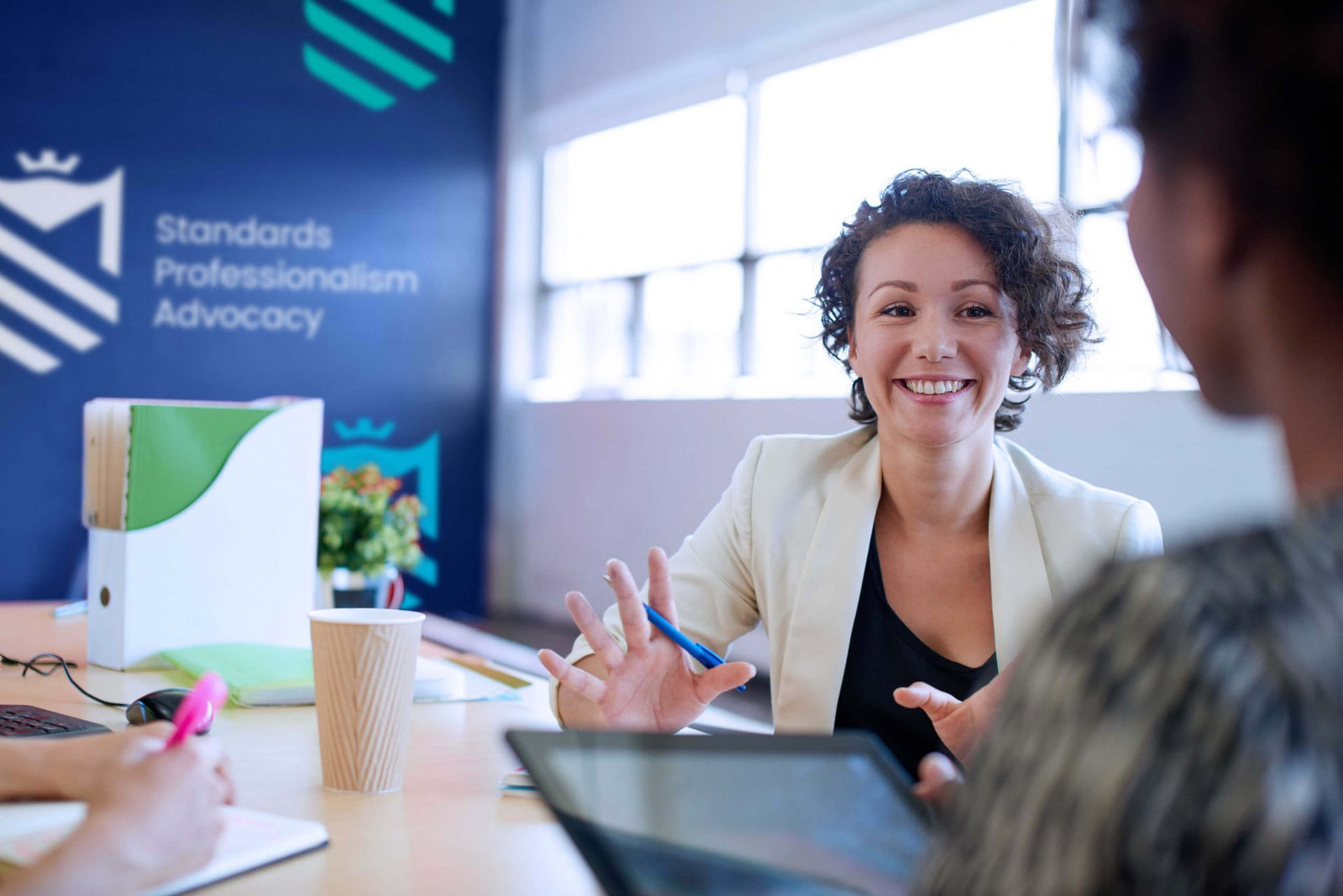 CIMSPA image of woman at a table talking to someone