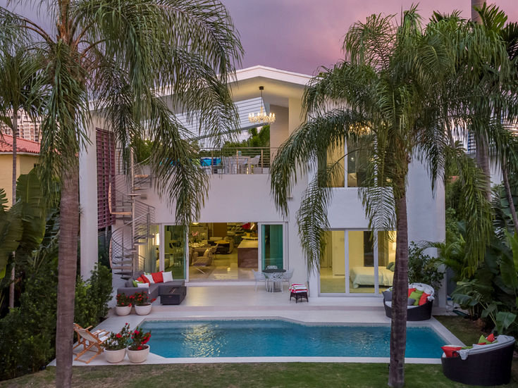 Une maison blanche contemporaine avec piscine et patio meublé, reflet du luxe, du design raffiné et élégance intemporellel