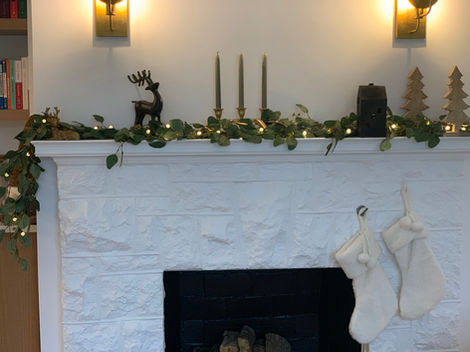a fireplace with stockings and candles on the mantle