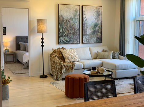 a living room with a couch and two paintings on the wall