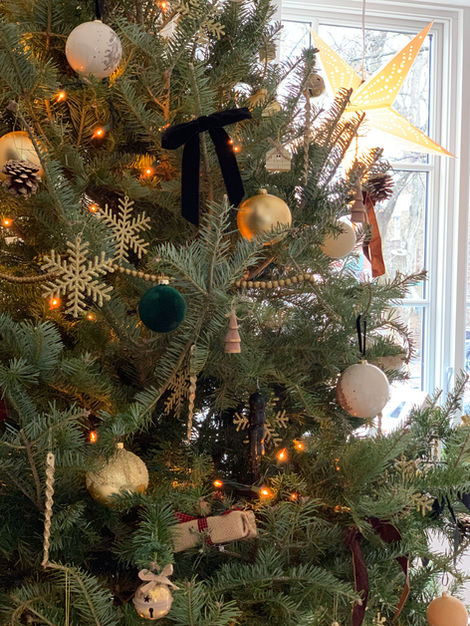 a christmas tree is decorated with gold and green ornaments