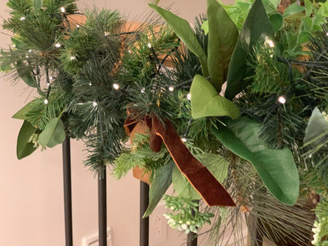 christmas decorations on a railing with a brown ribbon