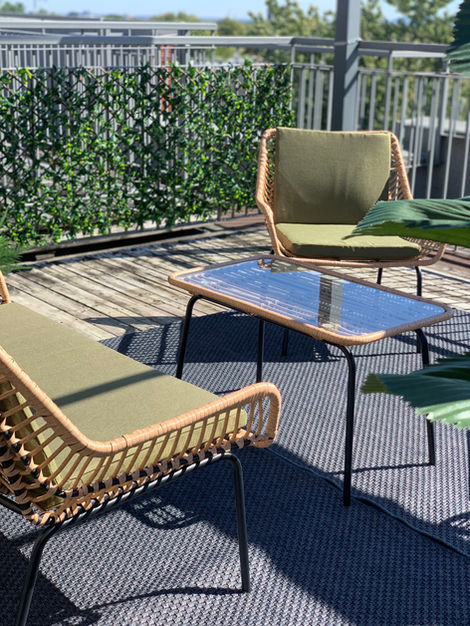 two chairs and a table on a deck with a green cushion