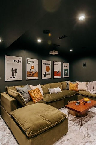Sous-sol trendy cosy et feutré, canapé velour vert kaki et affiches vintages