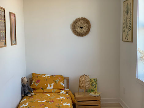 a bed with a yellow comforter with deer on it