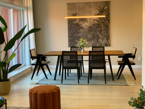 a dining room with a table and chairs and a painting on the wall