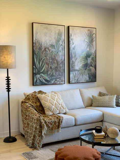 a living room with a couch and two paintings on the wall