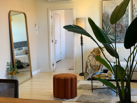 a living room with a large mirror and a plant