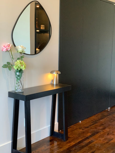 a vase of flowers sits on a table in front of a mirror