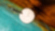 Overhead shot of a drink with straw on a colorful, textured surface.