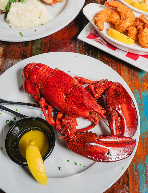 Steamed lobster with lemon and dipping sauce, served on a plate for dinner.