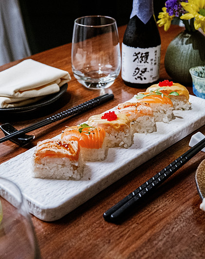 Sushi rolls on a white plate with chopsticks