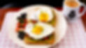 Avocado toast with two eggs and fruit on side