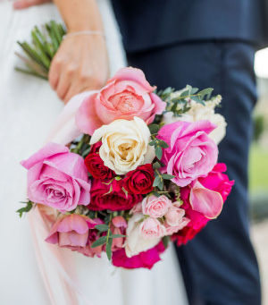 A vibrant bridal bouquet featuring dark pink, dusky pink and red garden roses, showcasing modern bridal style for a winter wedding by Corky and Prince.