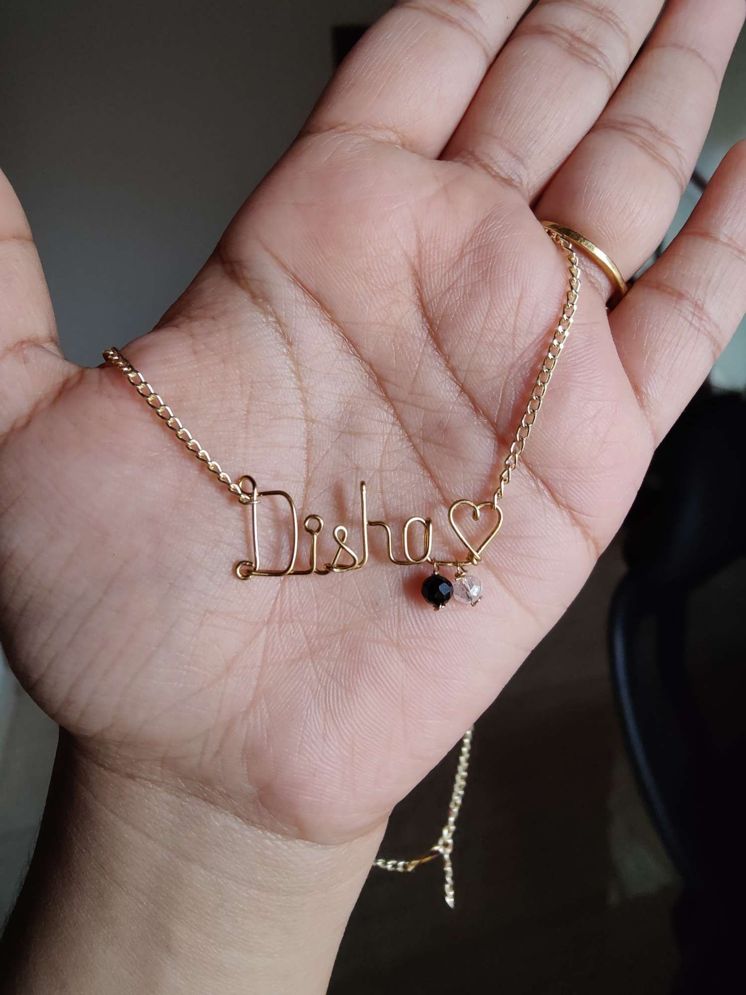 Name pendant chain with black and white hangings in gold