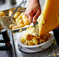 raclette cheese on potatoes live station