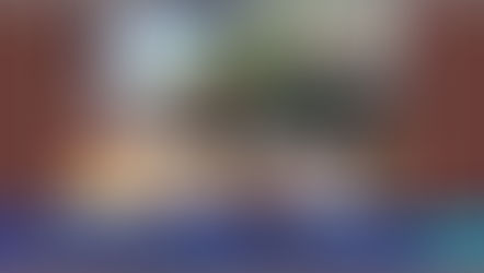 Homem e mulher trocam sementes em feira ao ar livre. Mesa com frascos e cabaças.