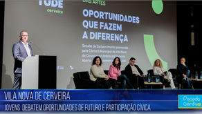 Presidente da Câmara de Vila Nova de Cerveira em pé em palco ao lado de painel de cinco pessoas. Tela exibe "Oportunidades que fazem a diferença". Ambiente de conferência.