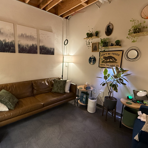 Tim Jackson's therapy office in East Nashville — a warm, relaxed room with a brown leather couch, plants, and soft lighting.