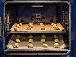 When cookies are placed on a flat pan that has a slight lip on both or just one edge, the heated air can circulate unimpeded which ensures the cookies will bake evenly. The lip just guides the flow of the heated air.