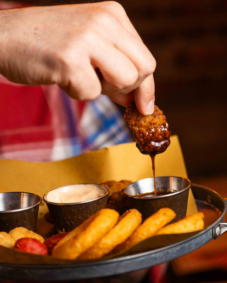 mano che intinge nugget in slasa bbq