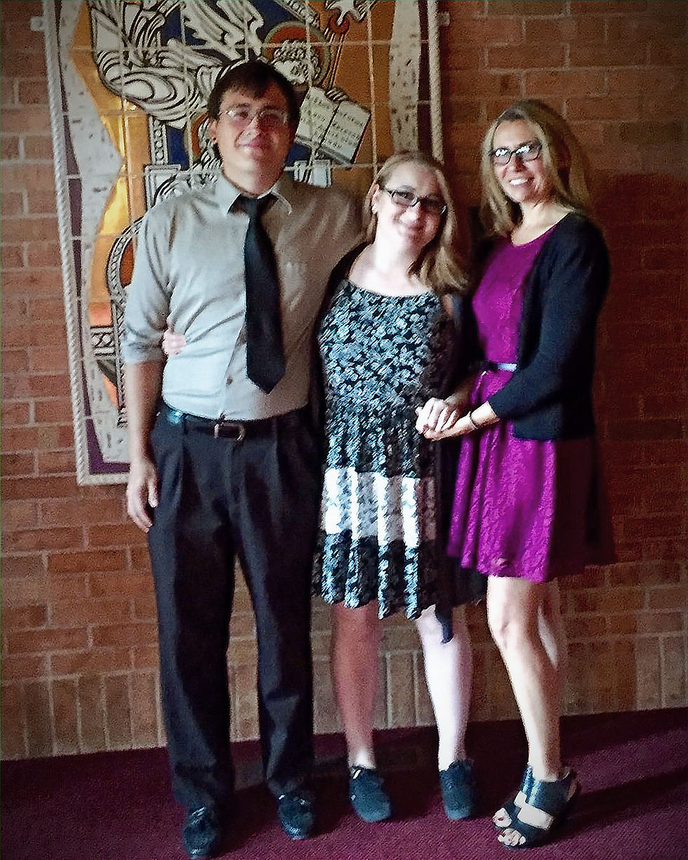 Three people standing in front of a painting