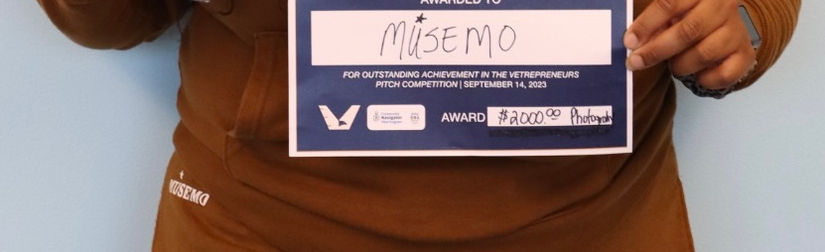 CEO holds challenge coin and certificate at pitch competition.