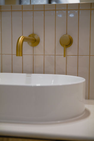 Bathroom renovation Gold Coast with brushed brass wall-mounted mixer and vessel basin detail in contemporary home.