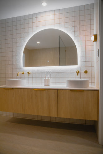 Double vanity bathroom renovation Gold Coast with fluted timber cabinetry, white stone benchtop and vessel basins.