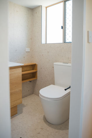 Ensuite shower with terrazzo tiles and matte black fixtures in Gold Coast home.