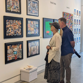 Couple viewing a wall of detailed works together