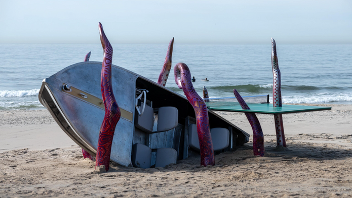Poster for Postcard from New York at Rockaway Beach: colorful tentacle sculpture on a sandy beach by the ocean