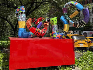 Colorful abstract sculpture in a leafy city park with text overlay: POSTCARD FROM NEW YORK, OUTSIDE, and Caprice in Motion info.