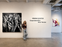 Ribana Szutor poses at Alessandro Berni Gallery beside a black-and-white painting; wall text reads RIBANA SZUTOR Suspended She: Inner Tension