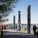 Poster for Guardian Spirit at Brooklyn Bridge Park with tall sculptures, people on waterfront walkway, and dog; Postcard from New York