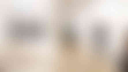 Visitors walking near a large photo reading “FINAL OK” and factory sketches