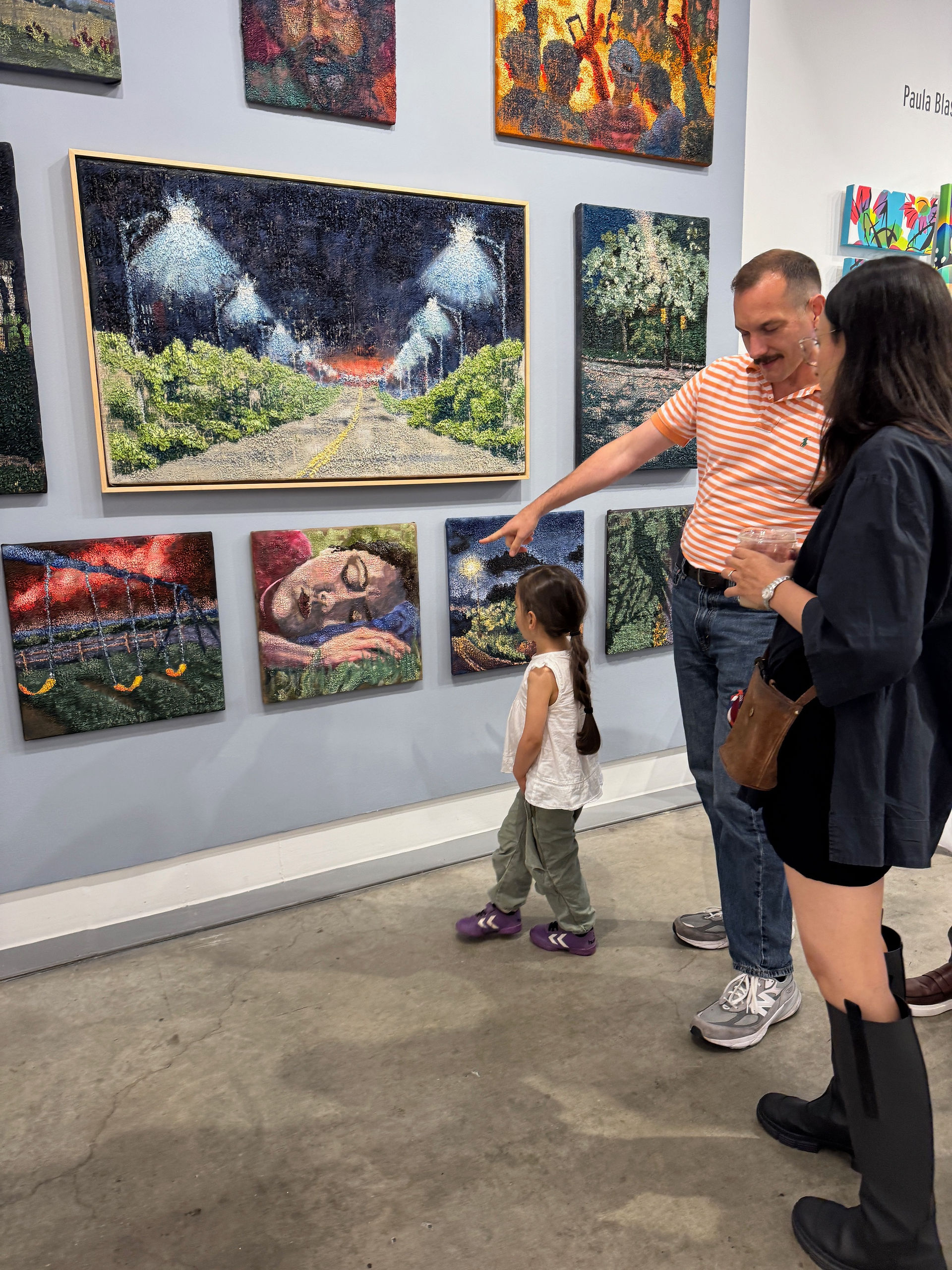 Man pointing out landscape artworks to a child