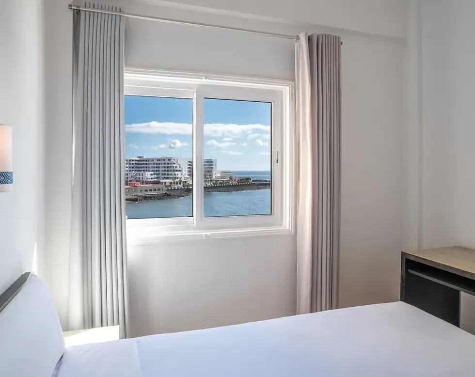 Zimmer mit Meerblick im Médano Hotel, mit Tageslicht und einem großen Fenster mit Blick auf den Atlantik.