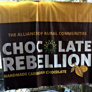 Brown and gold fabric sign for "Chocolate Rebellion" a project empowering rural women to produce handmade chocolate. 