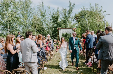 Groom and bride walking down the aisle outise Deane House at Calgary Alberta wedding