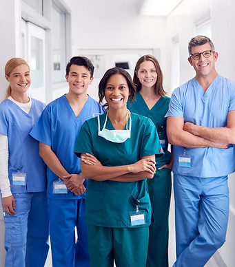 An image of 5 medical professionals smiling in their scrubs in a medical setting